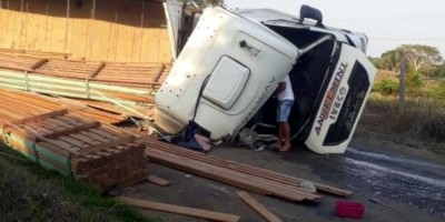 Caminhão carregado com madeira tomba em curva na RO-133 em Theobroma