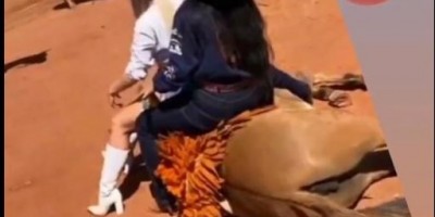 Mulheres sentam em cavalo deitado, supostamente exausto, durante Cavalgada em Rolim de...