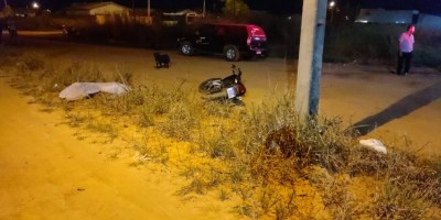 Motociclista morre na hora após bater contra carro e poste