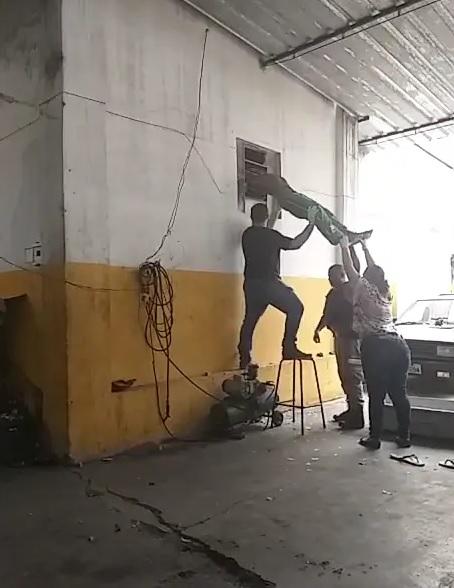 Imagens Fortes: Ladrão morre pendurado em janela após tentar roubar oficina mecânica em MG Imagens Fortes: Ladrão morre pendurado em janela após tentar roubar oficina mecânica em MG